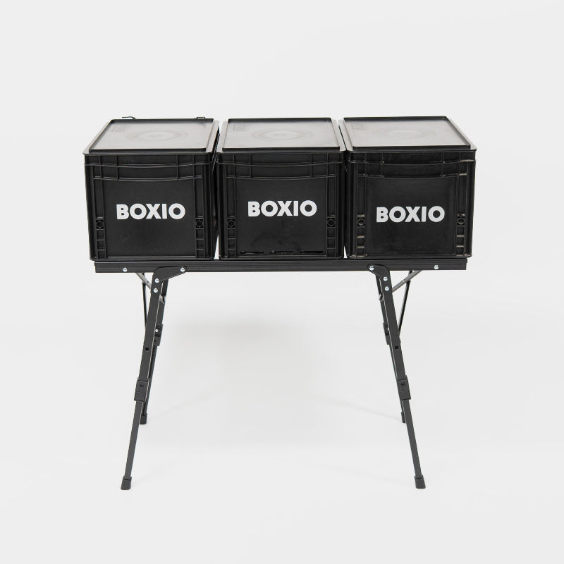 Black 'BOXIO' storage crates on a stand against a white background