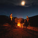 People seated in CLIQ ClassiQ 2.0 portable, lightweight, camping chairs around a camp fire