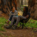 Two people in the woods seated on CLIQ ClassiQ 2.0 portable lightweight camping chairs