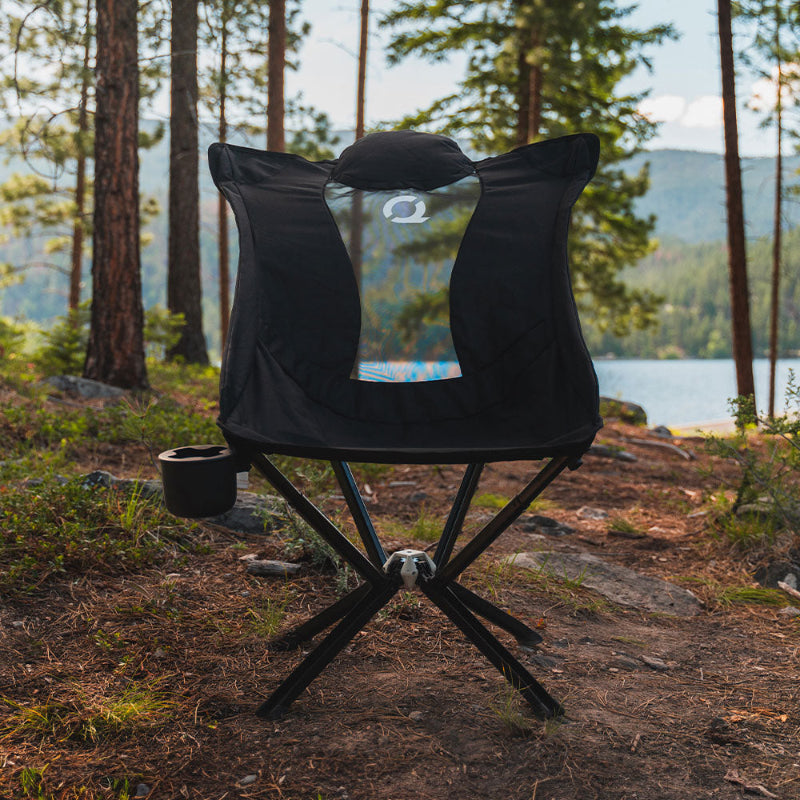 CLIQ EpiQ Lounge chair in black in a forest setting with a lake in the background