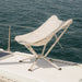 CLIQ Riviera foldable lounge chair in cloud white on a boat with ocean in the background