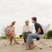Three adults with a baby sitting in CLIQ Riviera Lounge chairs on a beach, intuitive design sets up in 15 seconds