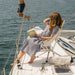 CLIQ Riviera Lounge chair in cloud white on boat with woman sitting in it features ergonomic canopy for all-day comfort