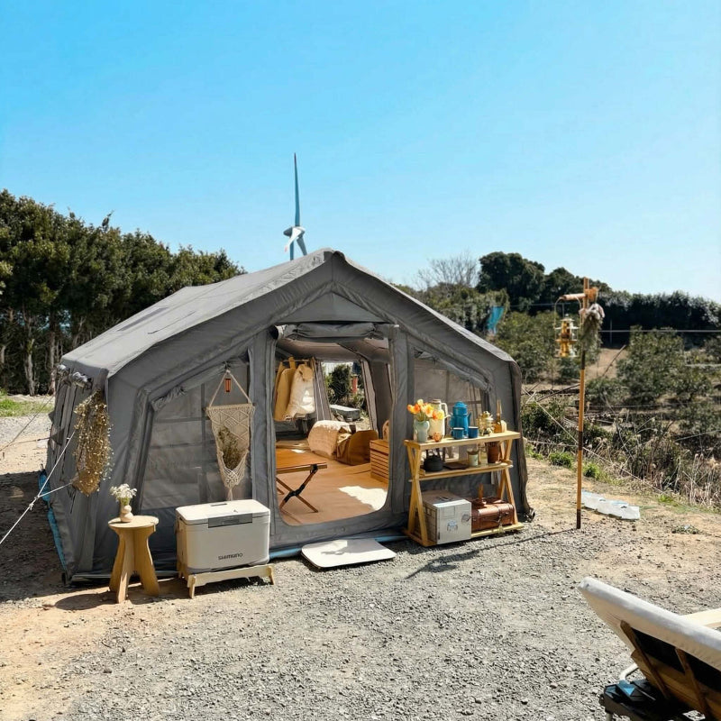 Coody 17.2 gray inflatable tent with interior view, outdoor furniture, and equipment in a natural setting.