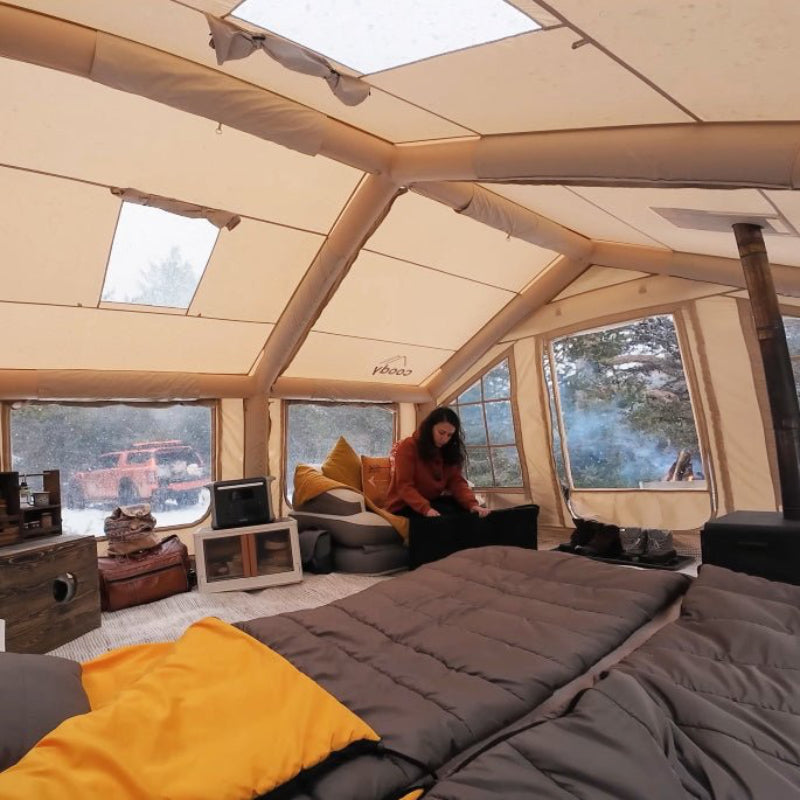Coody 17.2 Koala-7 beige inflatable tent interior view with person and furniture.