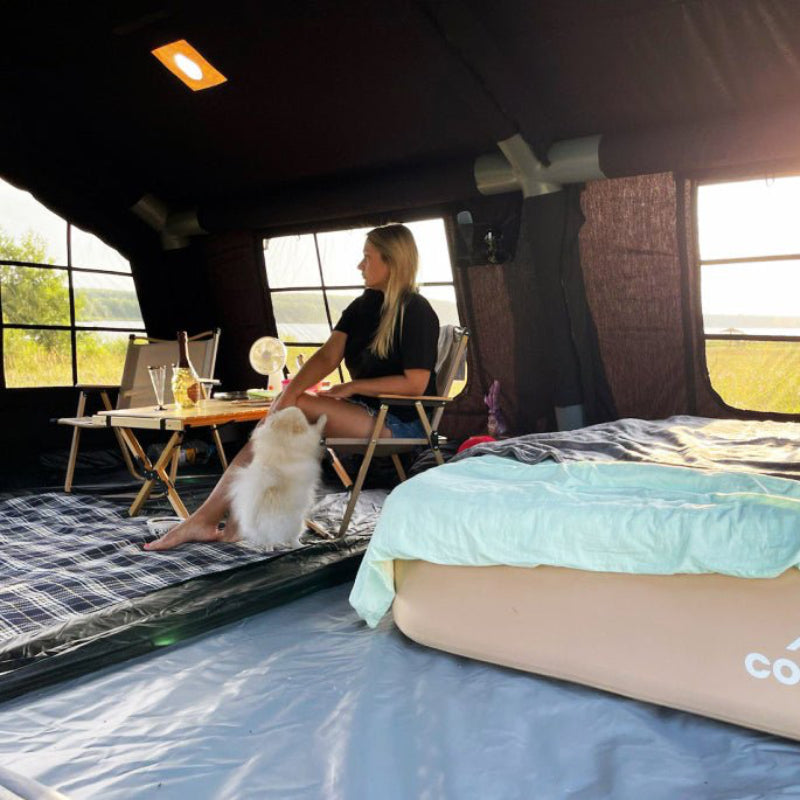 Coody 17.2 Koala-7 Black Inflatable Tent interior view with person and furniture.