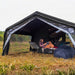 Coody AirTarp black  inflatable canopy with person and furniture.