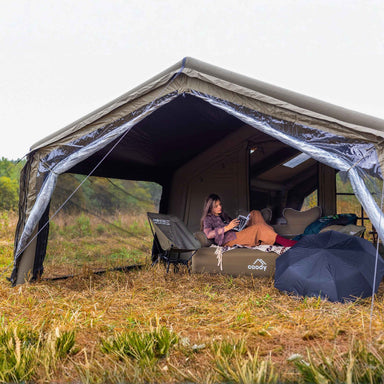 Coody AirTarp forest green inflatable canopy with person and furniture.