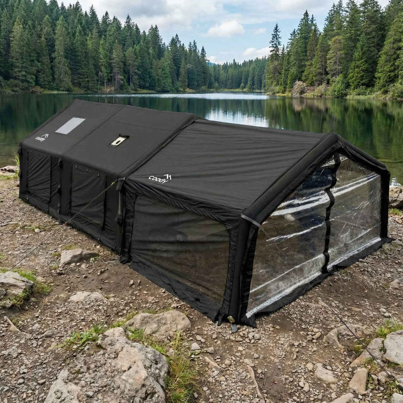 Coody AirTarp Inflatable Canopy extension in black exterior view amongst trees and water.