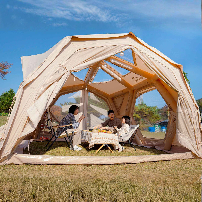 Coody Hub Shelter Pro beige inflatable tent with people inside sitting at table.