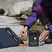 Person plugging a Jackery Explorer 300D compact portable power station and solar panel together outdoors.